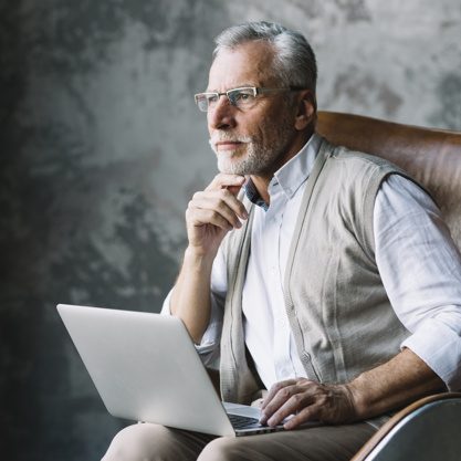 contemplated-elderly-man-sitting-chair-with-laptop-against-grunge-background_23-2147901042