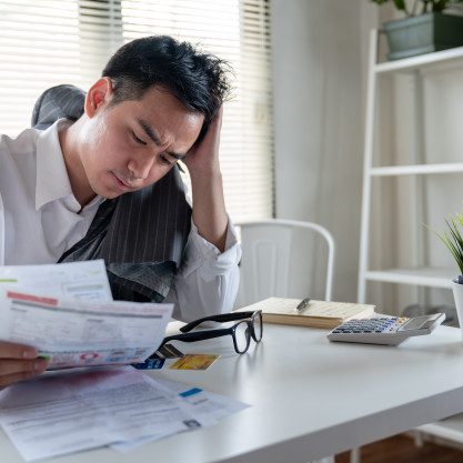 stressed-young-asian-businessman-holding-so-many-expenses-bills-such-as-electricity-bill-water-bill-internet-bill-cell-phone-bill-credit-card-bill-his-hand-no-money-pay-debt_34755-379