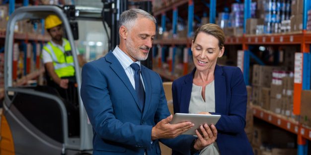 happy-managers-are-standing-looking-tablet_107420-41778