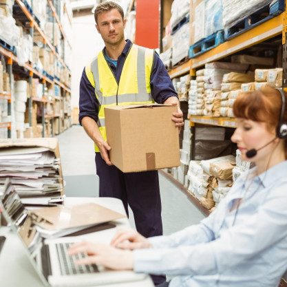 warehouse-manager-wearing-headset-using-laptop_13339-285036