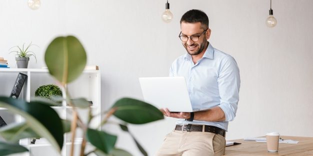 smiling-satisfied-man-30s-wearing-white-shirt-sitting-table-office-having-business-chat-silver-laptop_171337-39382
