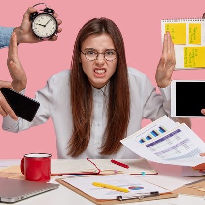 overworked-young-employee-refuses-all-things-frowns-face-annoyance-sits-desktop-with-paper-documents-notepad-isolated-pink-wall-female-worker-bothered-by-many-questions_273609-26173