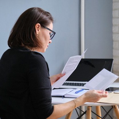 serious-mature-woman-holding-business-papers-hands-documents-received-envelopes-by-mail_116407-7781