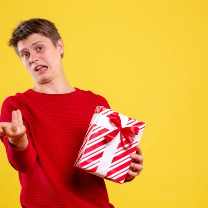 front-view-young-male-with-xmas-present-yellow-background_179666-17013