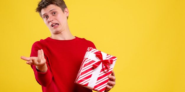 front-view-young-male-with-xmas-present-yellow-background_179666-17013