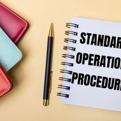 multi-colored-diaries-lie-beige-wall-pen-notebook-with-words-standard-operation-procedure-flat-lay_380694-475