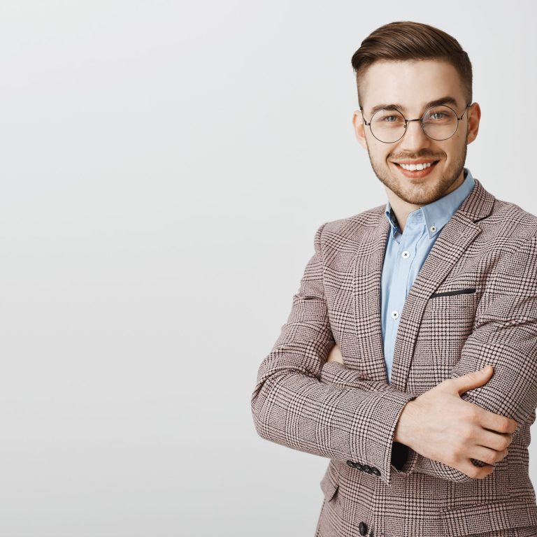 Ambitious smart and intelligent good-looking european male entrepreneur in glasses and stylish jacket crossing hands on chest and smiling in self-assured smile assuring his company best
